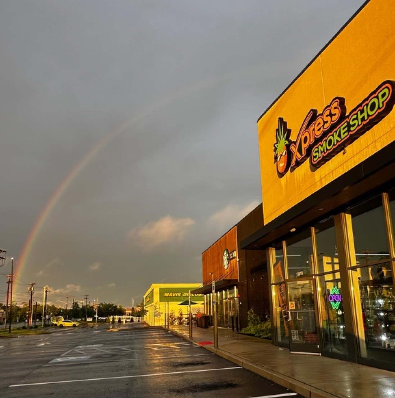 Xpress Smoke Shop with the rainbow in the background.